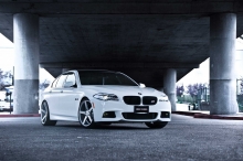 Белый BMW 5 series между опор моста